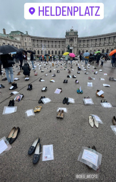 Aufreihung von gesammelten Schuhen mit Zettel vor dem Heldenplatz